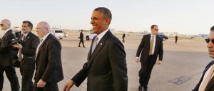 U.S. President Barack Obama smiles as he is surrounded by U.S. Secret Service agents after arriving at Dallas Love Field in Texas