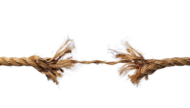 Frayed rope about to break isolated over a white background
